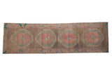 Distressed vintage Northwest Persian rug runner with large geometric medallions in muted blush, jade, and ochre.