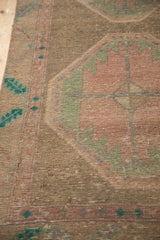 Distressed hand-knotted texture, faded geometric motifs, and serrated border on vintage Persian rug.