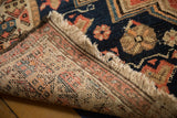 A corner view of the antique Malayer runner's hand-knotted foundation and colorful front pile.