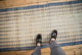 Distressed vintage Oushak runner displaying rows of dusty blue and mint diamond motifs.