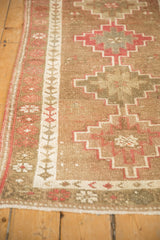 Visible wear and germinating vine border detail on distressed vintage Kurd runner.