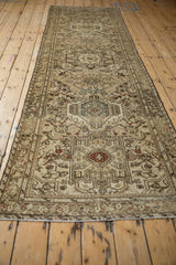 Angled view of a distressed Karaja runner, showing the full length of its repeating medallion pattern.
