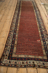 Antique Kurdish Hamadan runner's madder root red field with repeating boteh and animal motifs.