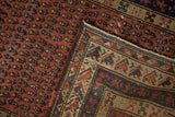Hand-knotted construction of an antique Kurdish Hamadan rug showing madder red field, sapphire boteh motifs, and woven back.