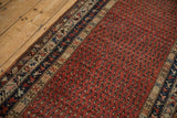 Antique Kurdish Hamadan runner field with madder red boteh pattern and geometric sapphire blue borders.