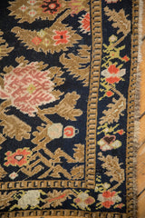 Serrated leaf border and hand-knotted low pile texture of an antique Karabagh runner.