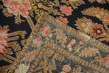 Corner of an antique Karabagh rug folded to show the hand-knotted weave and foundation.