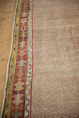 Faded red hexagonal field and red, yellow geometric border on vintage Oushak rug with wear.