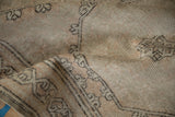 Textured pile with muted neutral tones and intricate border on a distressed vintage Sparta rug.