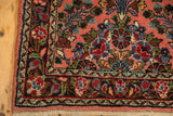 Vintage Dargezine rug corner; dusty rose field with floral vines, madder red border, and fringe.