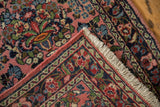 Vintage Dargezine runner corner, dusty rose floral field, dark blue border, and ivory fringe.