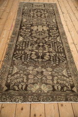 Distressed vintage Dargezine runner detail, chocolate brown, repeating floral bouquets, muted silver-green motifs.