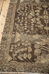 Distressed Dargezine runner detail showing chocolate brown pile, platinum floral motifs, and visible wear.