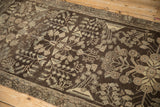 Chocolate brown Dargezine runner with platinum floral bouquets, meandering vines, and visible even wear.