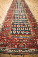 Hand-knotted Persian Bijar runner's cherry red henna border and navy quatrefoil floral field.