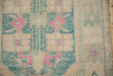 Detail of distressed Oushak runner pile with primitive motifs in cream, dusty turquoise, and pink.