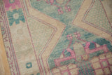 Distressed Oushak runner texture with muted pink, dusty teal, and cream geometric patterns.
