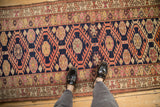 Distressed Kurd runner close-up, geometric serrated gul pattern in navy, peach, and blush.