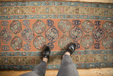 Geometric floral guls covering the madder root red field of the Antique Persian runner.