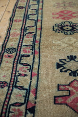 Faint foundation showing through on distressed Kurd runner with gold field and pink motifs.