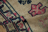 Distressed vintage Kurd runner pile showing gold abrashes, navy, and pink geometric motifs.