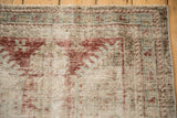 Distressed texture of antique Mahal runner, revealing foundation, worn cherry red, and pale blue.