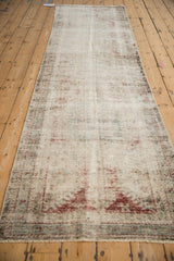 Heavily distressed pile of antique Mahal rug, revealing foundation with faded red, blue, ivory.