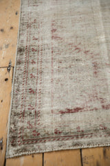 Distressed antique Mahal runner with exposed foundation, faint ivory and cherry red pattern.