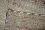 Detailed view of a distressed Mahal rug's hand-knotted foundation and worn ivory pile.