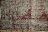 Close-up of antique Mahal runner's distressed pile, revealing foundation, red, blue border, and fringe.