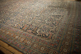 Worn navy field of the Antique Khorassan carpet, revealing stylized dragon arabesques and vinery.