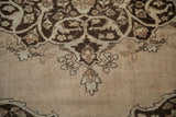 Scalloped spandrel detail on a vintage Tabriz carpet showing low, even wear and brown arabesques.