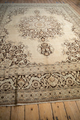 Grounded perspective of a vintage Tabriz carpet's spacious medallion design in brown and sand tones.
