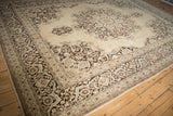 Angled view of the vintage Tabriz carpet highlighting its scalloped medallion and brown floral border.