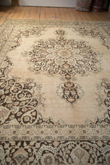 Perspective view showing the grand scale and medallion design of a vintage distressed Tabriz carpet.