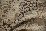 Softly draped vintage Tabriz carpet showing the textured pile and brown arabesque details.