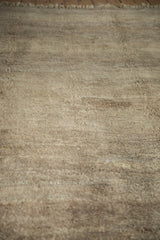 Plush wool pile texture of a vintage Moroccan carpet in natural beige and sand tones.