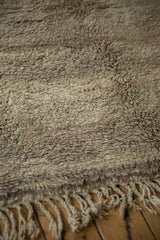 Thick plush pile of vintage Moroccan carpet in tone-on-tone beige, sand, and greige with fringe.