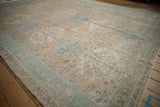 Textured distressed Karaja rug showing geometric gul medallions in muted apricot and sky blue.