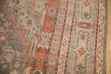 Geometric and floral patterns of a distressed vintage Khotan rug in faded red, grey, and cream.