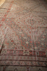 Distressed vintage Khotan carpet detail with brick red geometric border and muted floral field.