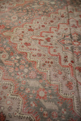 Distressed vintage Khotan carpet detail, visible knot heads, brick red and oxidized silver floral motifs.