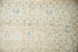 Distressed vintage Sparta carpet close-up, beige field, cobalt blue palmettes, visible wear.