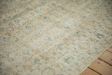 Distressed Sparta carpet detail with visible knot heads and faded beige-blue floral pattern.