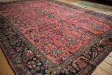 Vintage Lilihan rug detail: dusty raspberry field, intricate floral sprays, navy border.