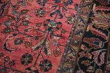 Vintage Lilihan carpet featuring dusty magenta field with floral sprays and a dark navy border.