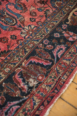 Vintage Lilihan carpet's dusty magenta field, navy border, and scrolled floral palmettes.