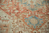 Close-up on the distressed, low pile of a Heriz carpet showing its hand-knotted texture.