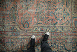 Distressed Persian Lilihan carpet showcasing worn ruby red field with floral sprays and palmettes.