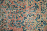 Distressed vintage Lilihan carpet texture with intricate ruby red and blue floral pattern.